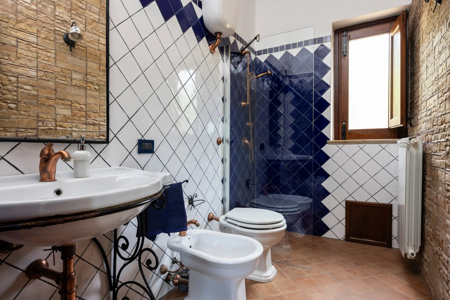 Un baño alicatado con lavabo, inodoro y ducha.
