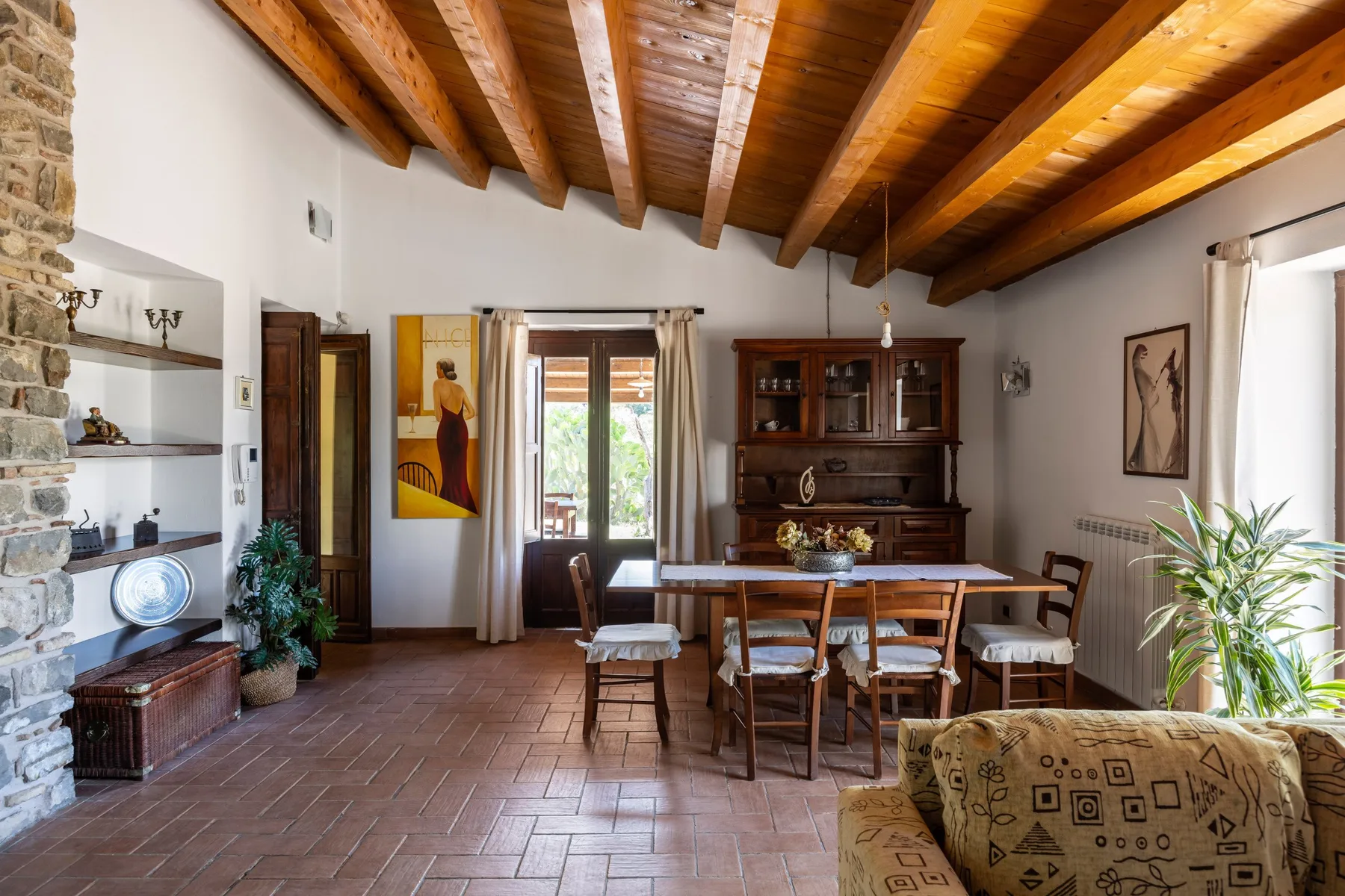 Una sala de estar y comedor rústica con vigas de madera y una mesa de comedor.