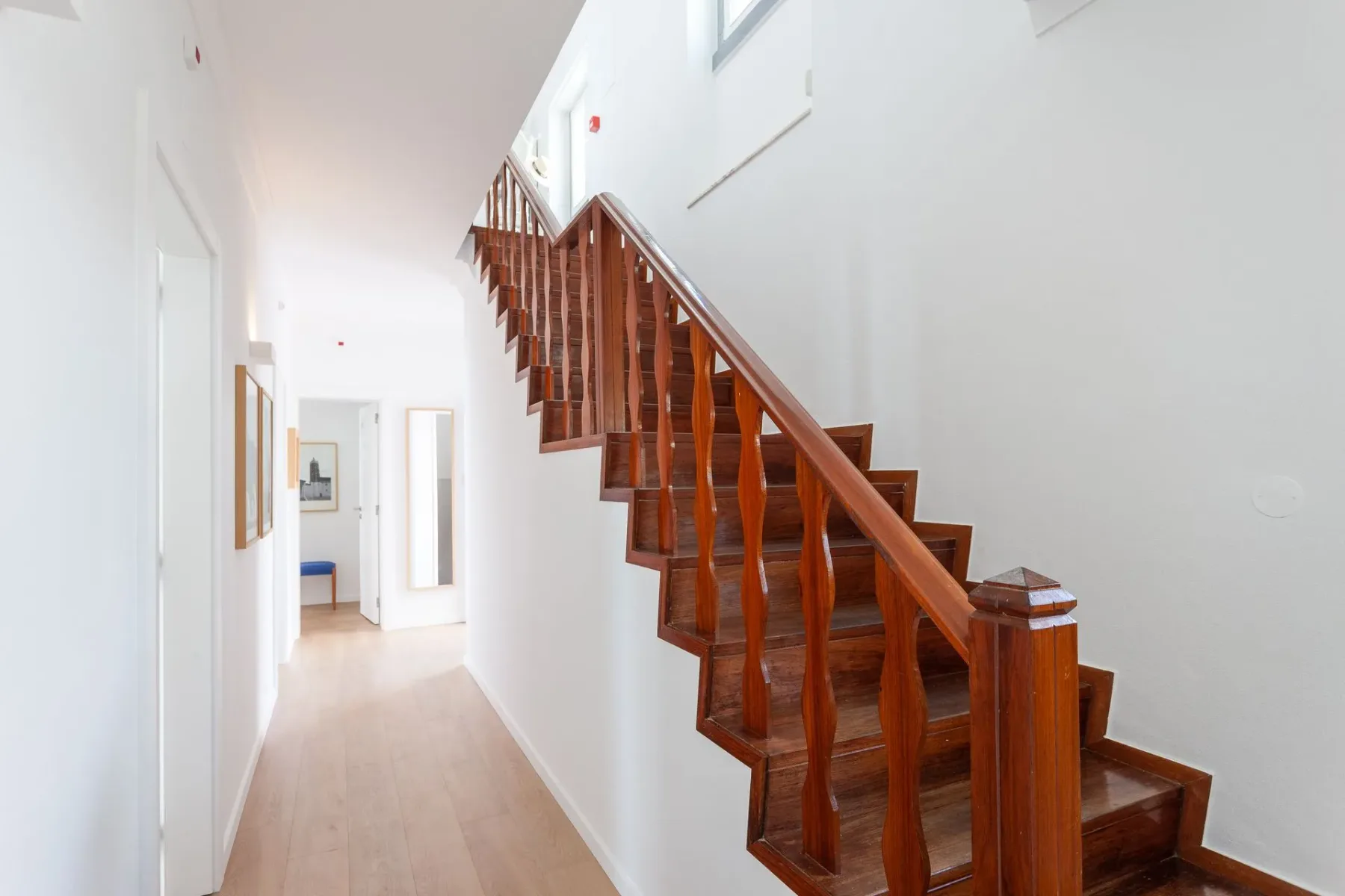 Pasillo con una escalera de madera que lleva al segundo piso