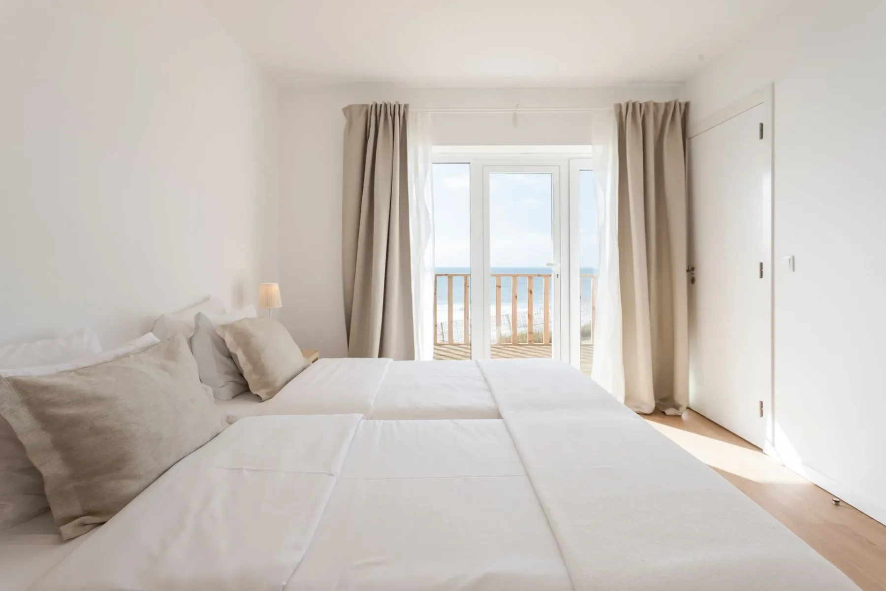 Dormitorio con dos camas y un balcón con vistas al océano