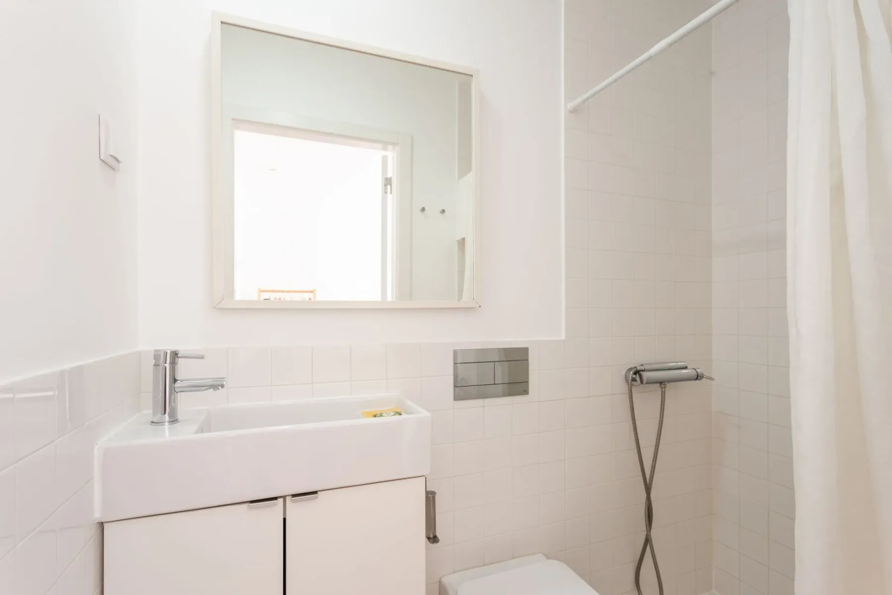 Baño con lavabo, inodoro, espejo y ducha