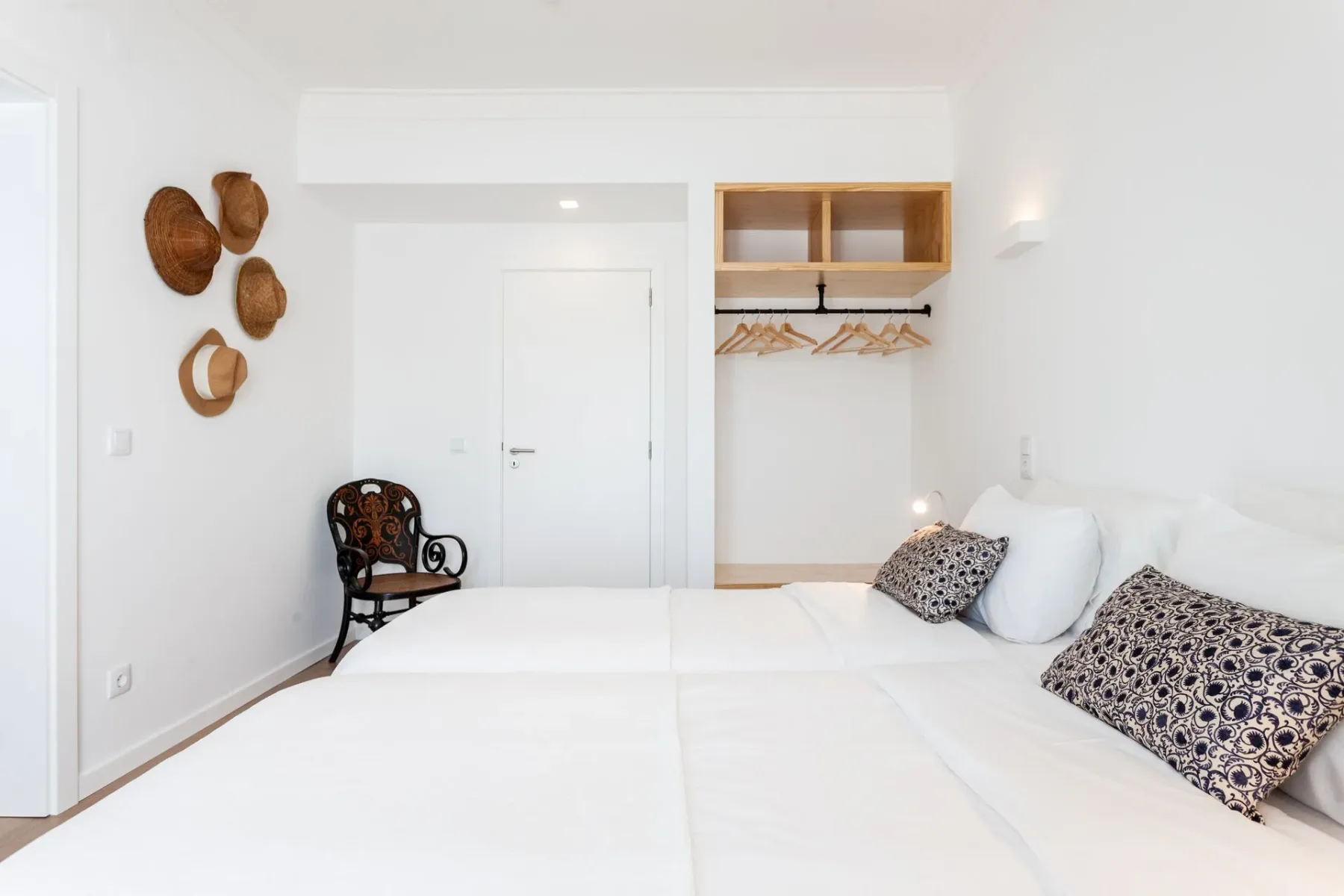 Dormitorio con dos camas, una silla y un armario
