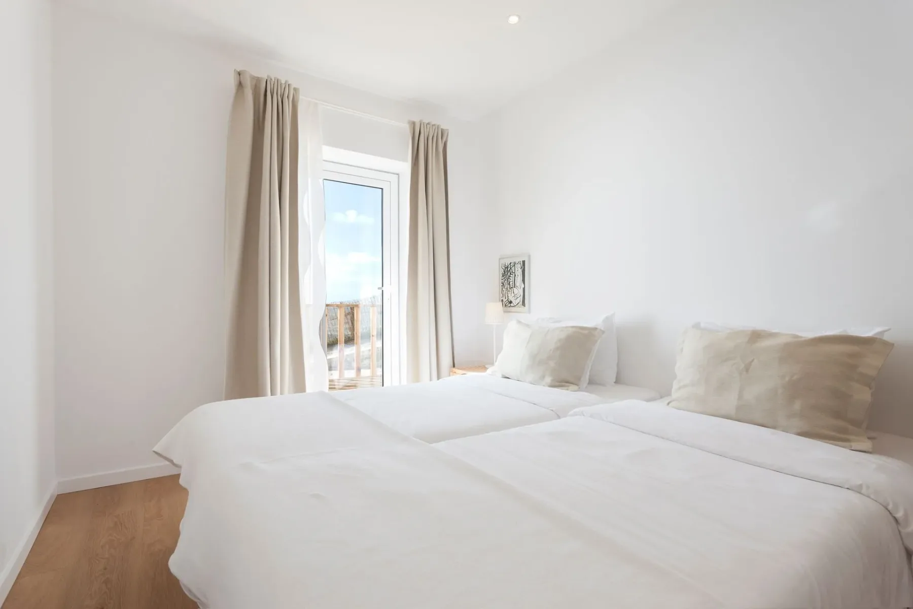 Dormitorio con dos camas y una puerta corrediza de vidrio