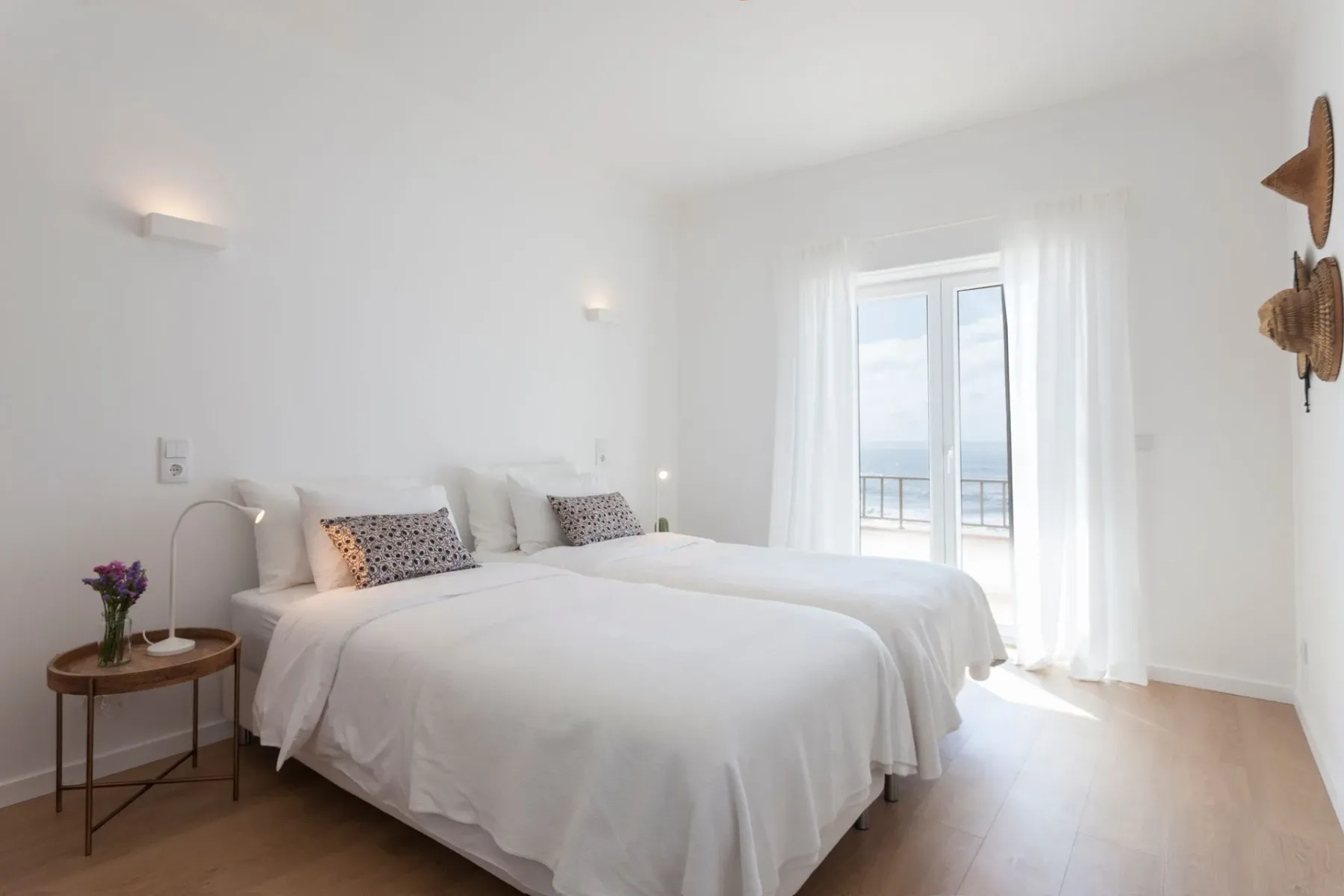 Dormitorio con dos camas y una puerta corredera de vidrio