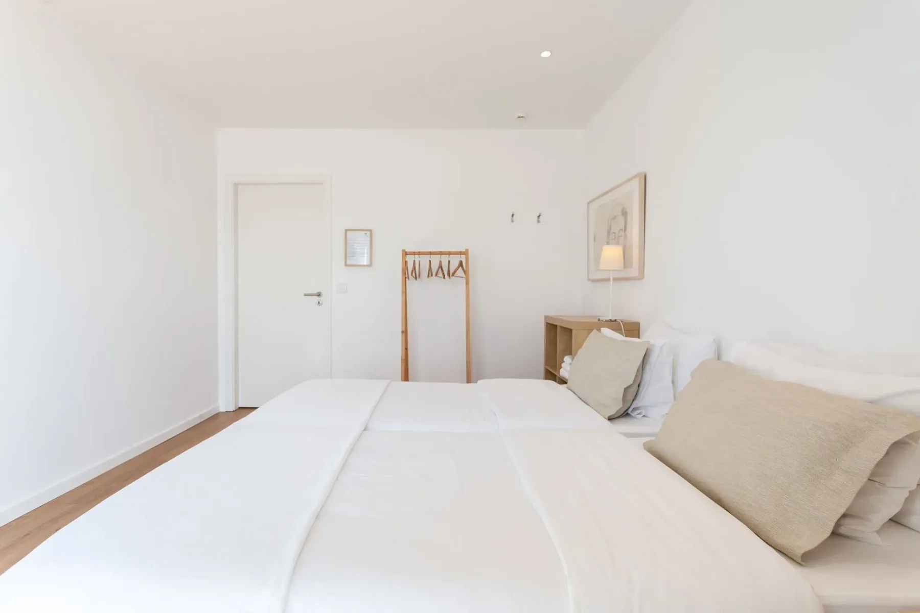 Dormitorio con dos camas y un perchero de pared
