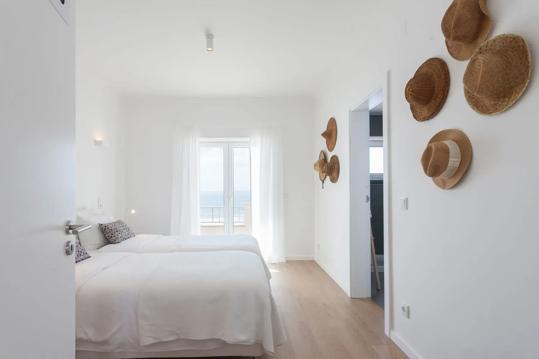 Dormitorio con dos camas y sombreros en la pared