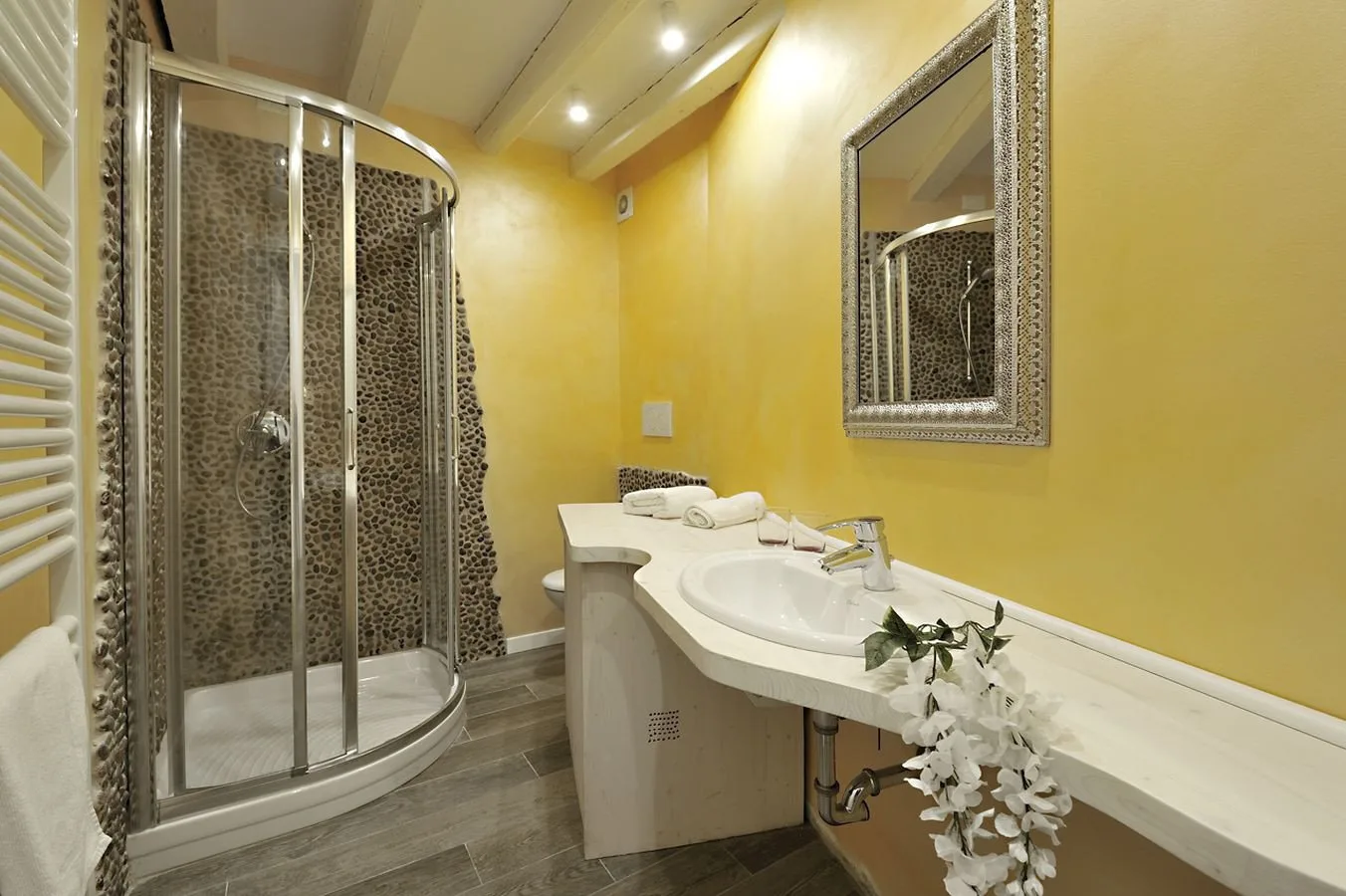 A bathroom with a glass-enclosed shower and a curved sink counter.