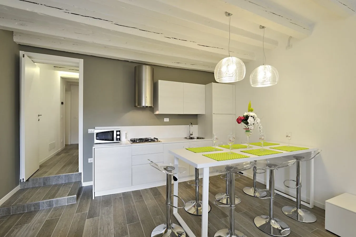 A bright modern kitchen with white cabinetry and a dining island.