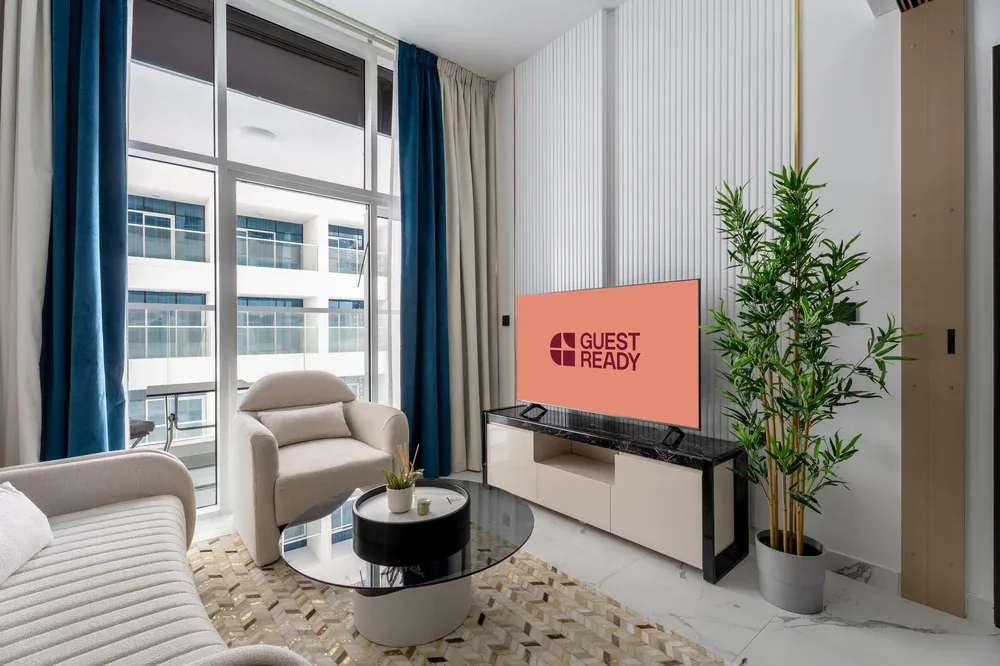 Una sala de estar moderna con televisor, asientos y una ventana grande.