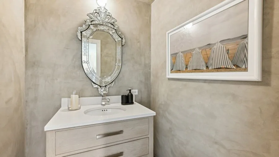 A bathroom vanity with a framed nautical sailboat picture on the wall.