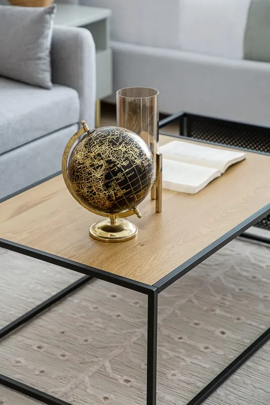 Una zona de estar con un globo terráqueo y libros sobre una mesa de centro.