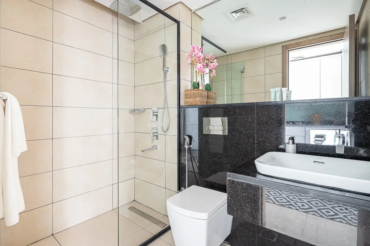 Un baño moderno con ducha de vidrio, inodoro y lavabo.