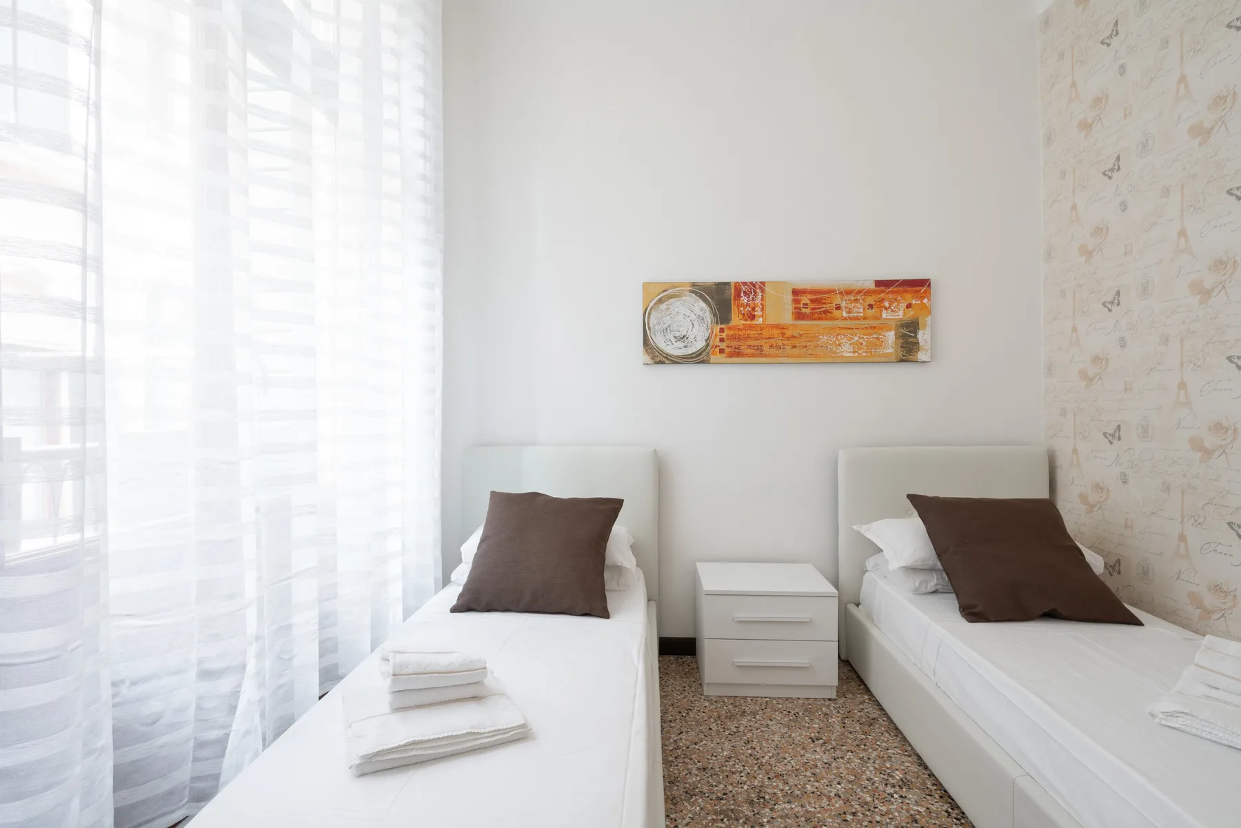 Un dormitorio con dos camas individuales y una mesita de noche entre ellas.
