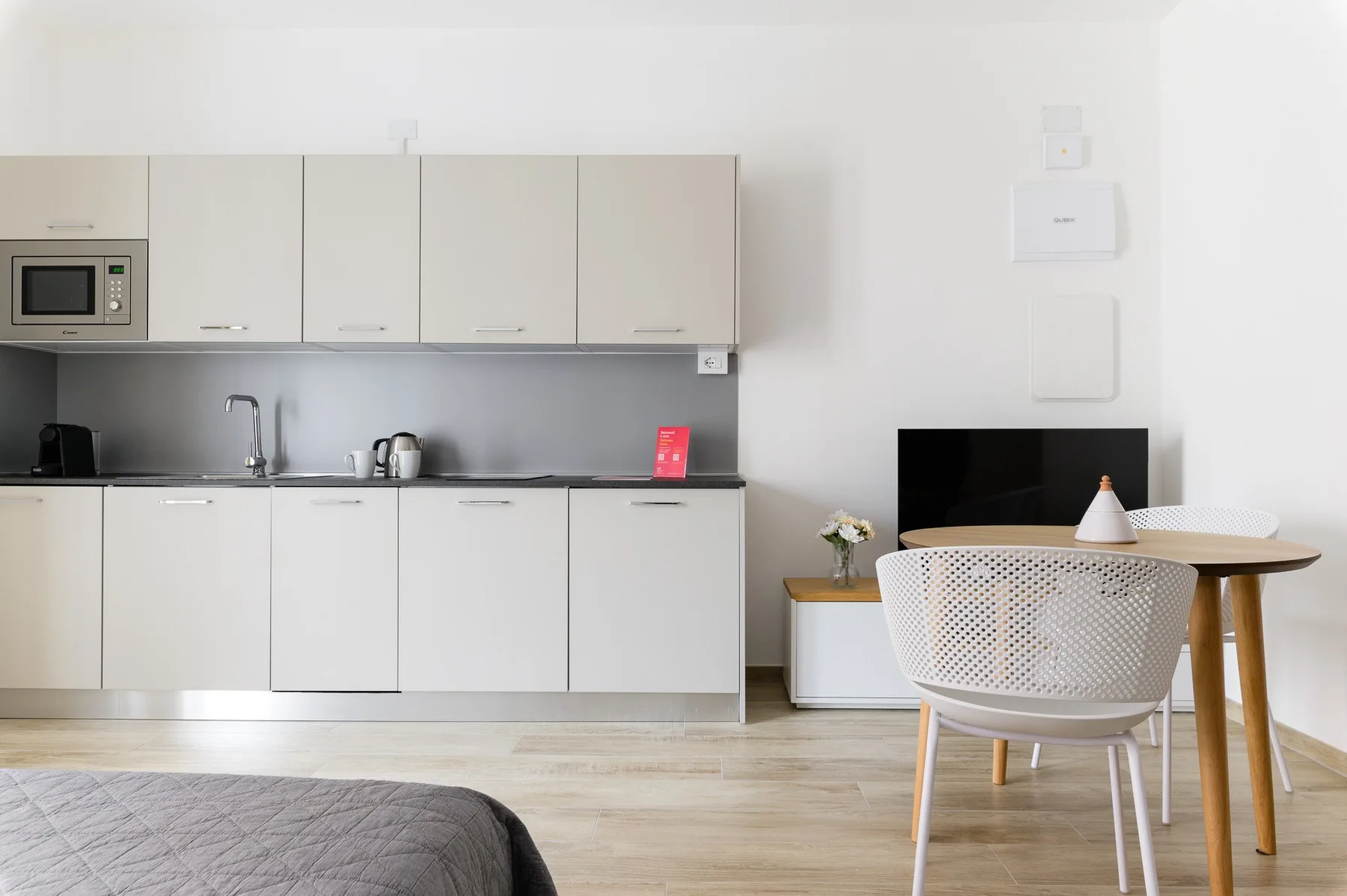 Una cocina y comedor luminosos con gabinetes claros y una mesa redonda.