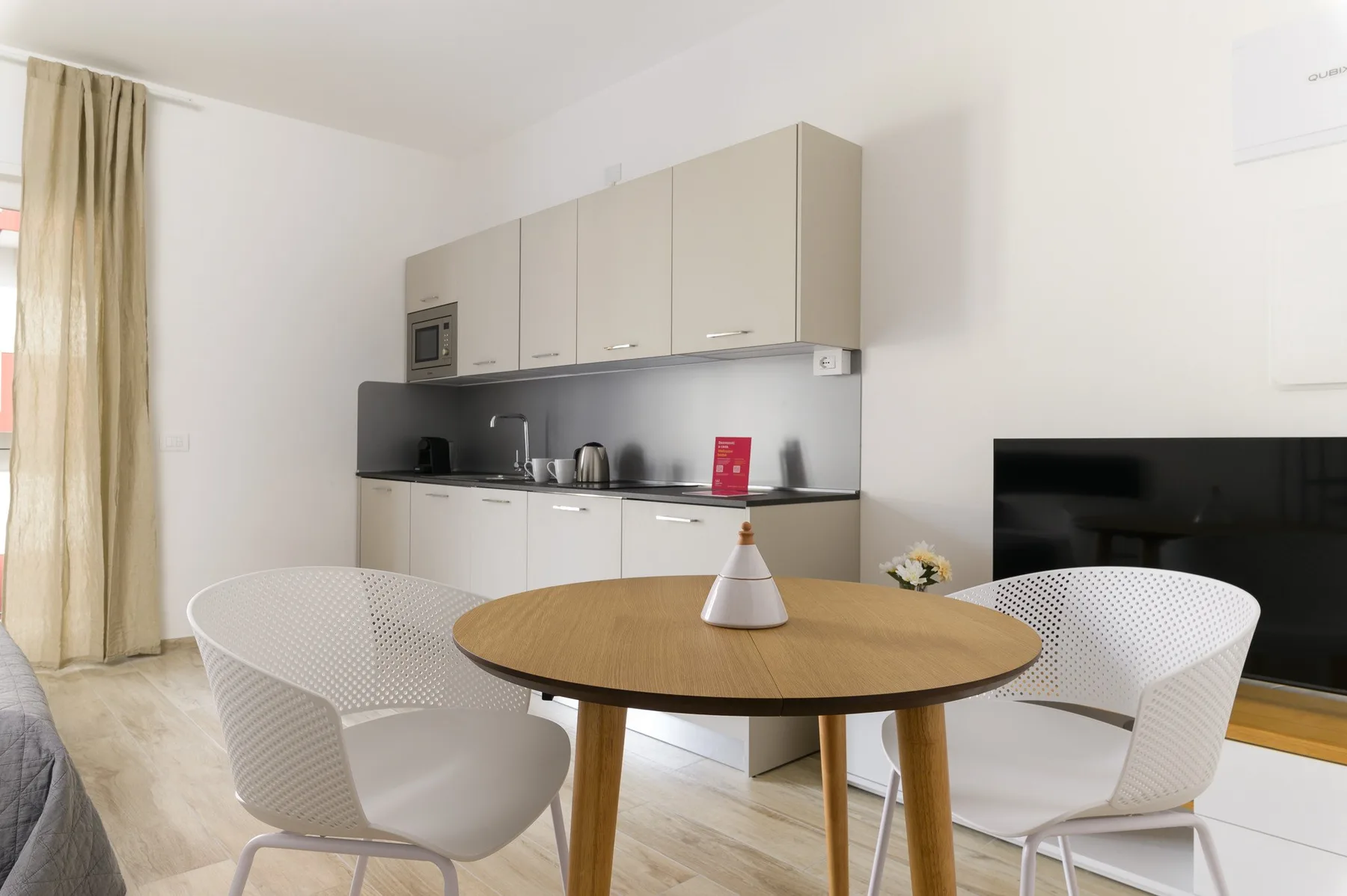 Comedor con una mesa redonda y una cocina pequeña junto a la pared.