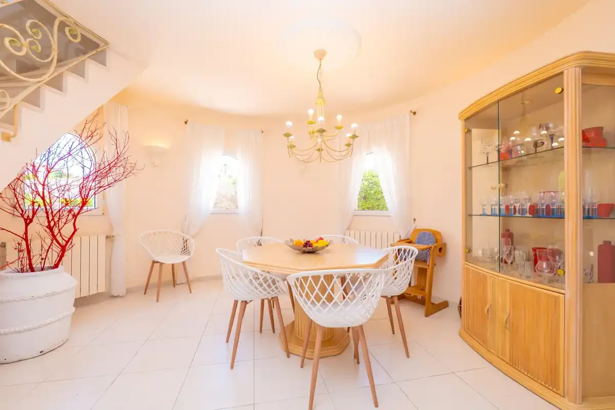 A bright dining room with a table and display cabinet.