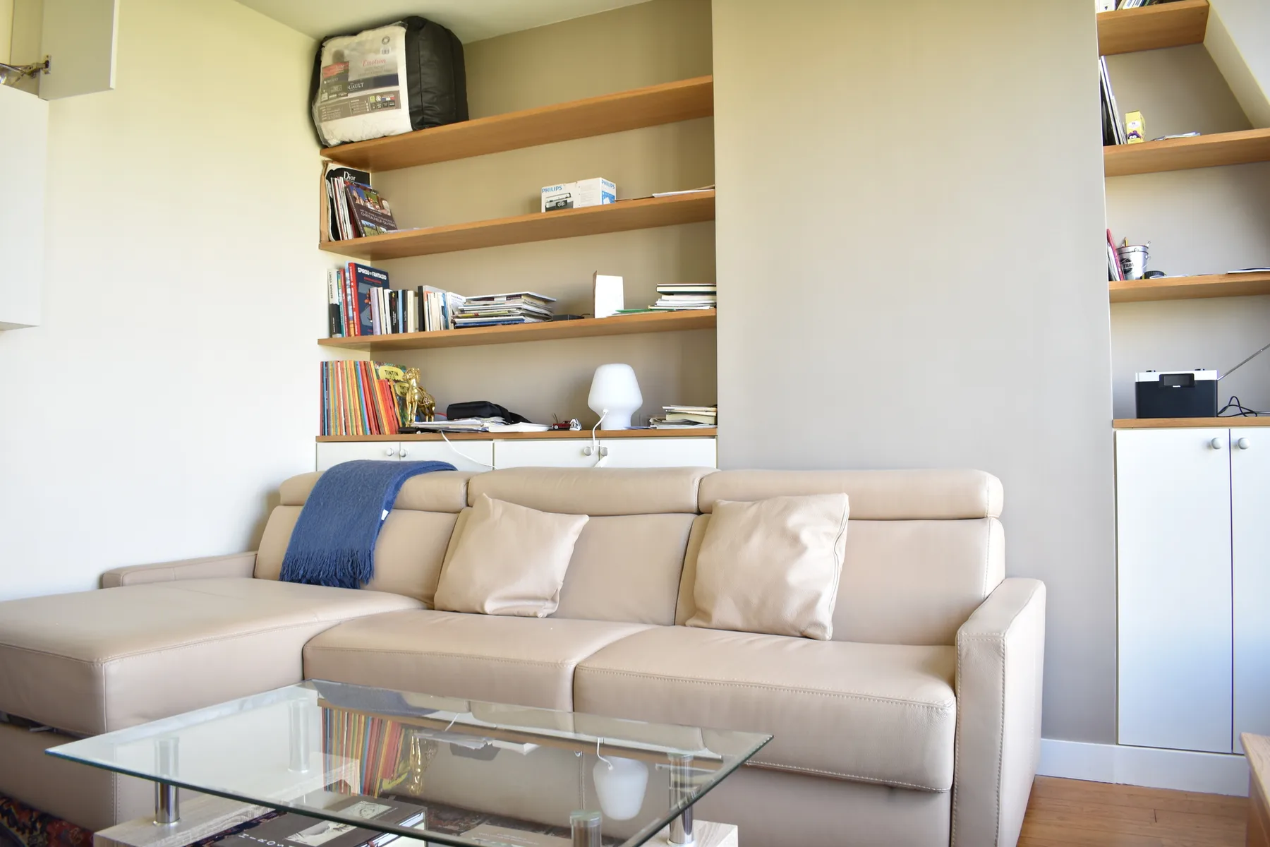 A living room with light-colored seating and built-in shelves.