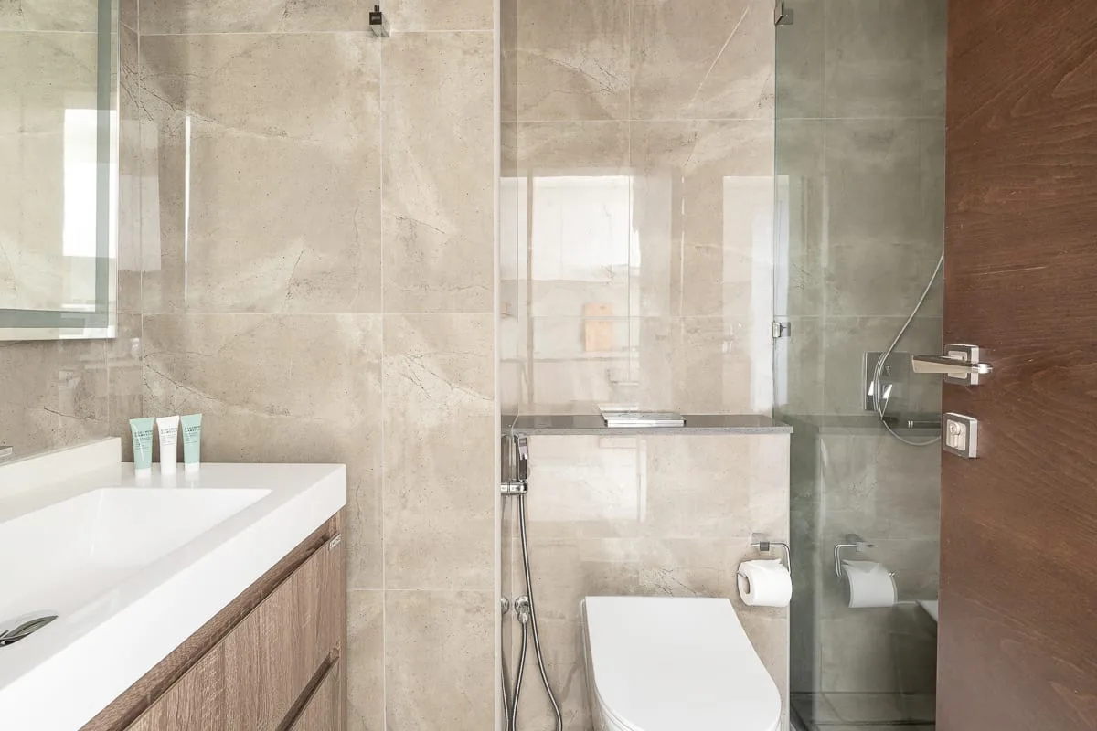 Un baño con lavabo blanco, inodoro y ducha de vidrio.