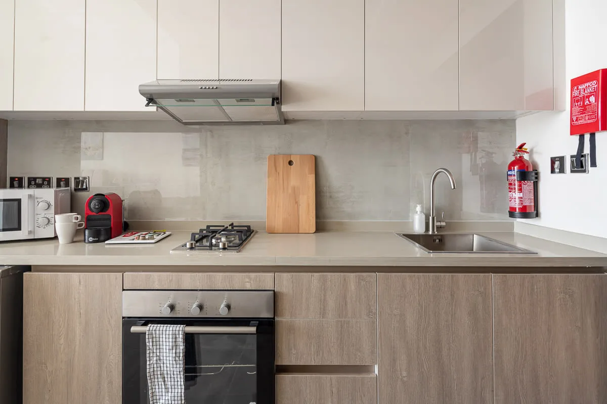 Una cocina moderna con encimera, fregadero y horno empotrado.