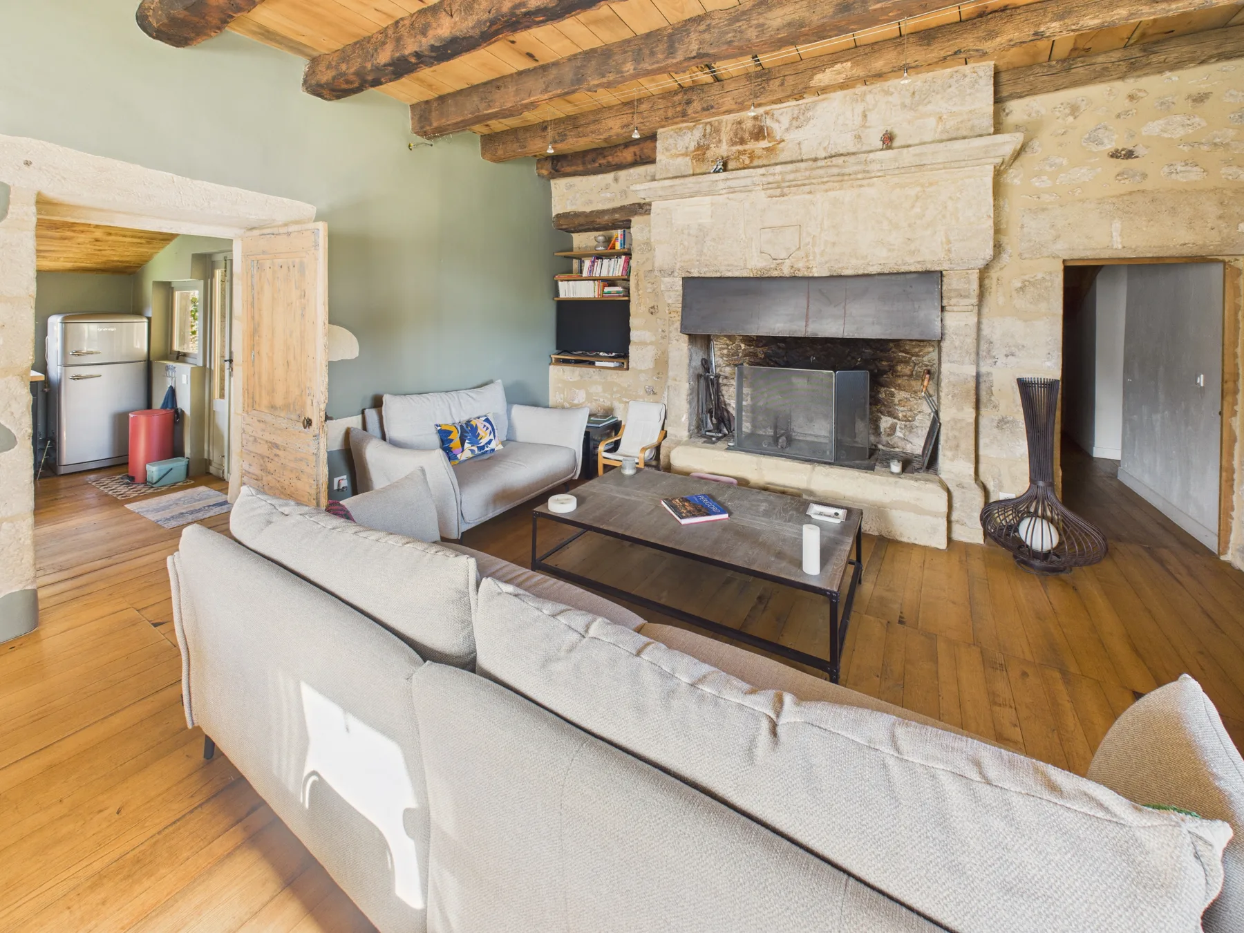 A living room with seating arranged around a fireplace and coffee table.