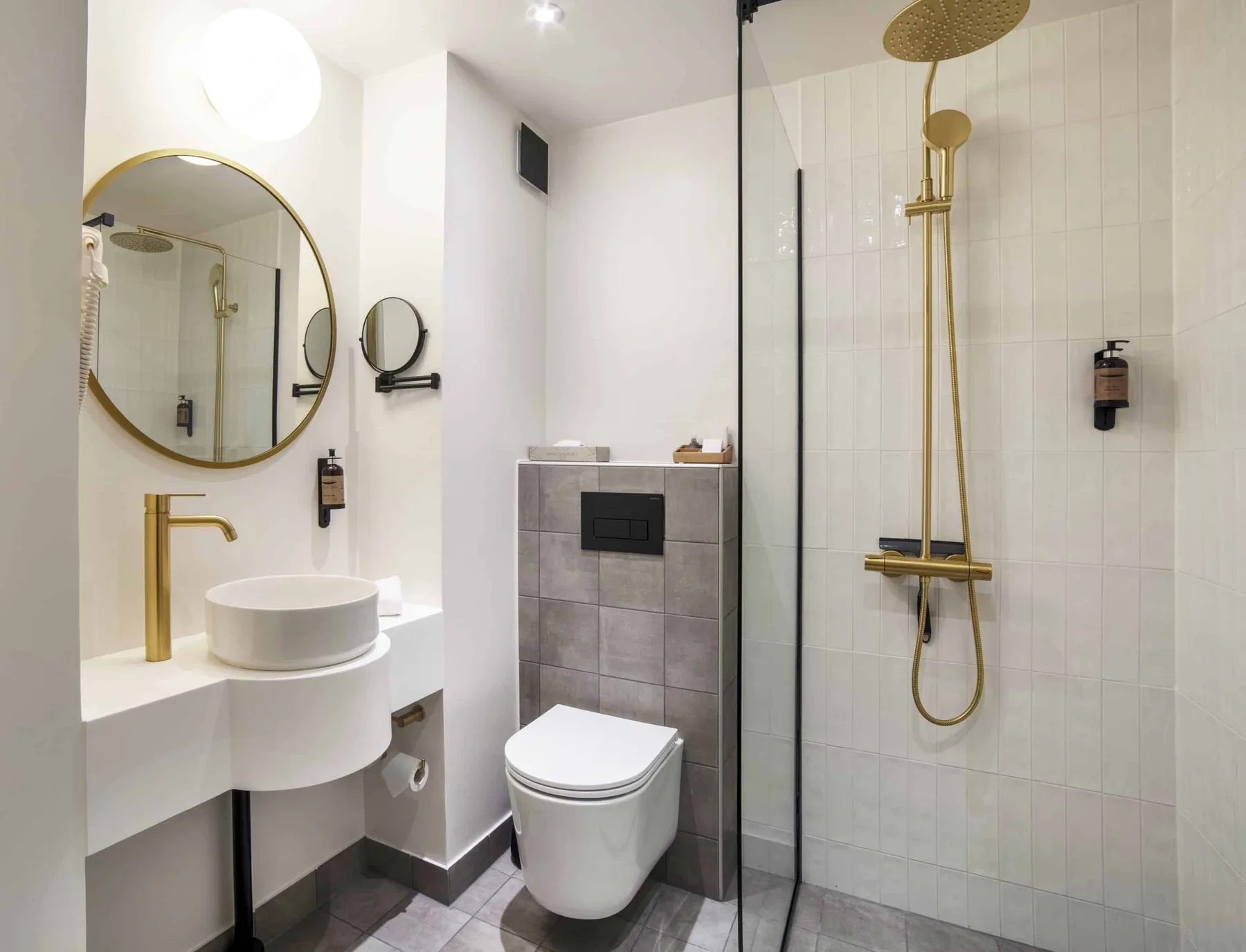 Baño con ducha, inodoro, lavabo, espejo, toalla y artículos de aseo