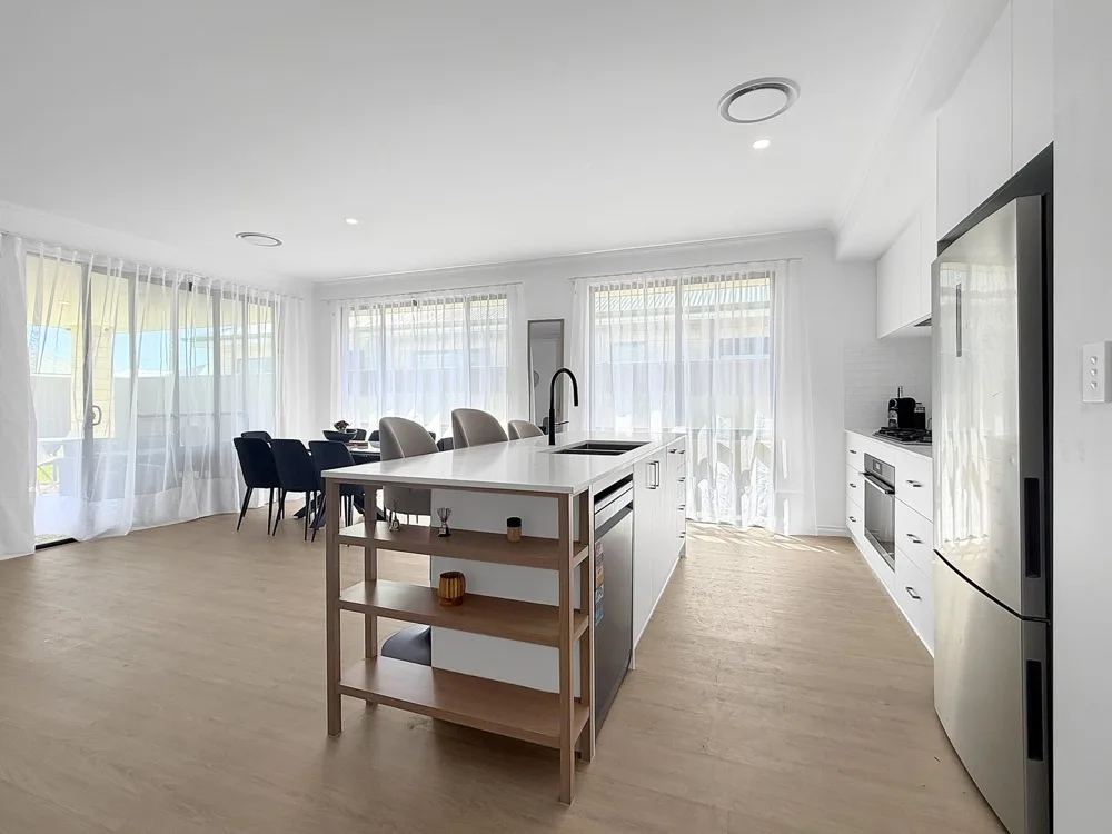 Cocina luminosa con una isla y una zona de comedor.