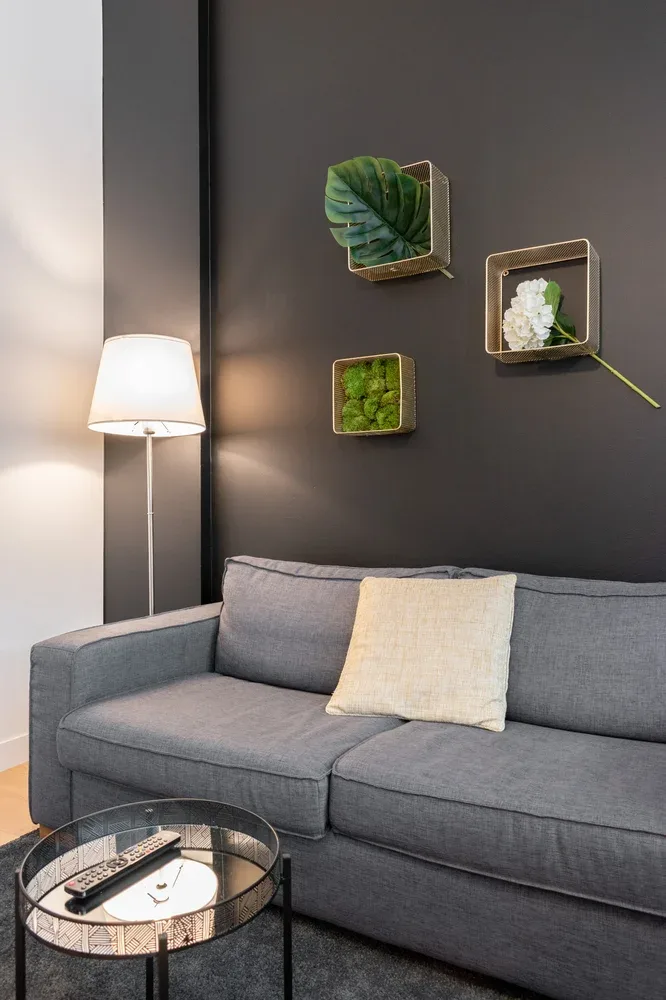 A living room seating area with a gray sofa and a floor lamp.