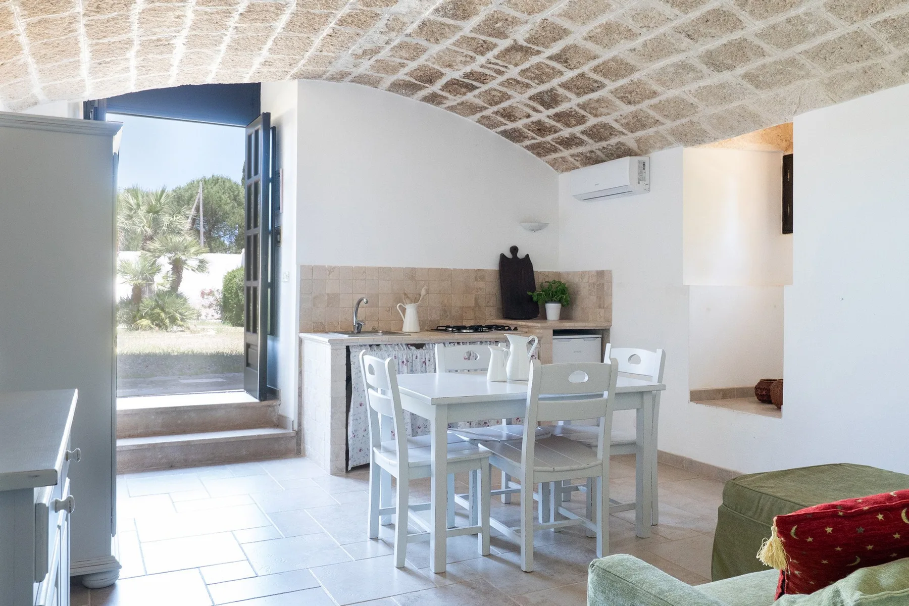 A bright dining area with a table and chairs beside an open doorway.