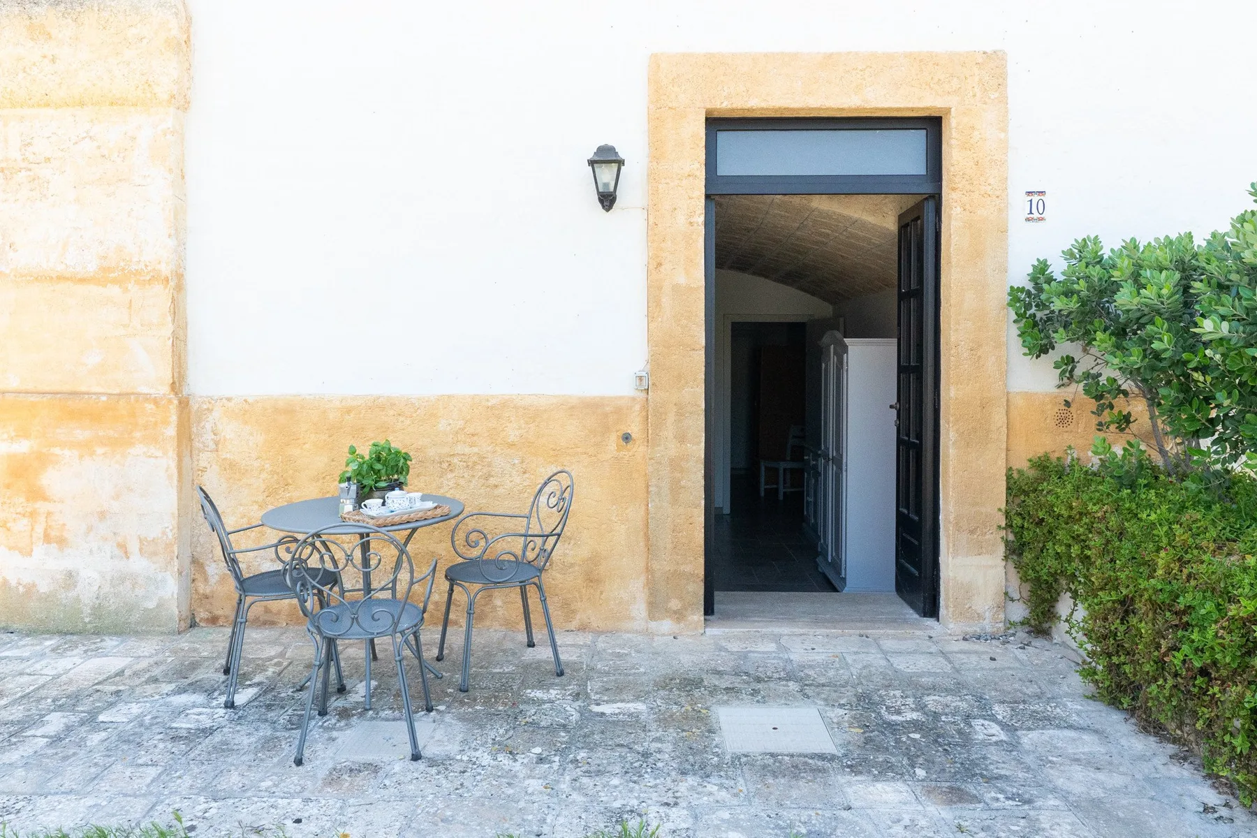 An exterior doorway opens beside a small outdoor seating area.