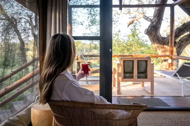 Guest looking out from a safari tent deck