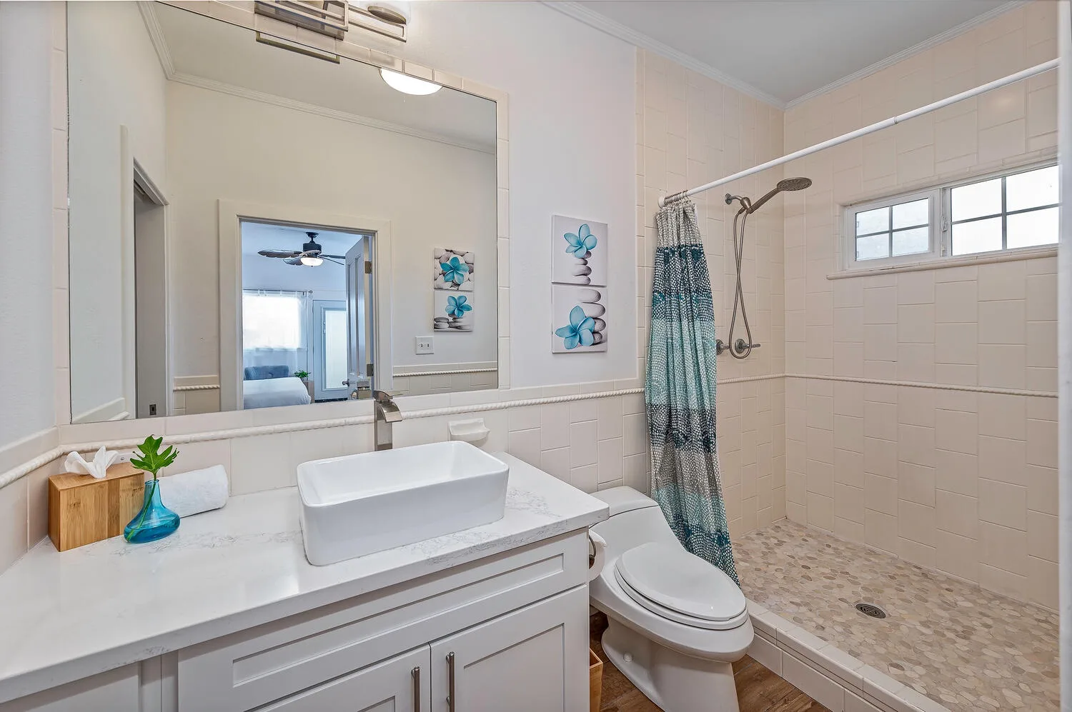 Un baño luminoso con lavabo, inodoro y ducha.