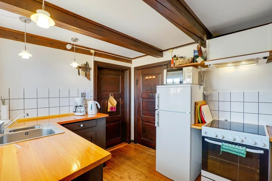 A kitchen with a countertop, sink, refrigerator, and stove.