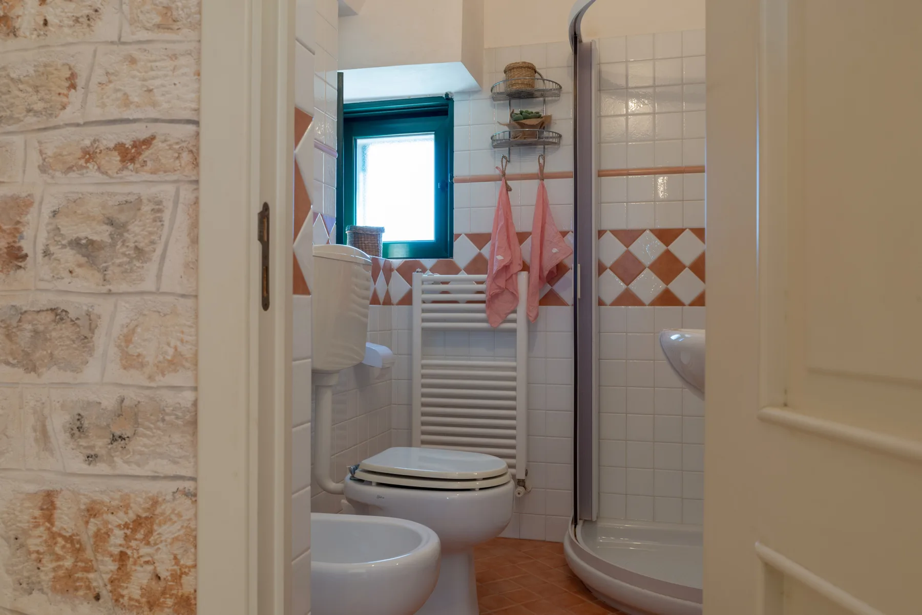 Un baño con azulejos, inodoro, lavabo y ducha.