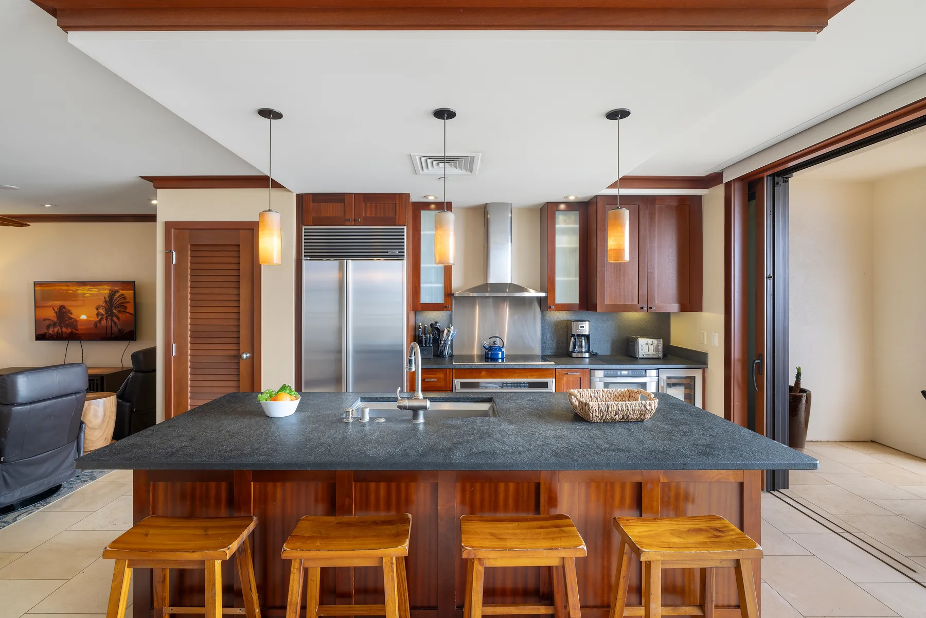 Una cocina abierta con una isla grande y taburetes de madera.