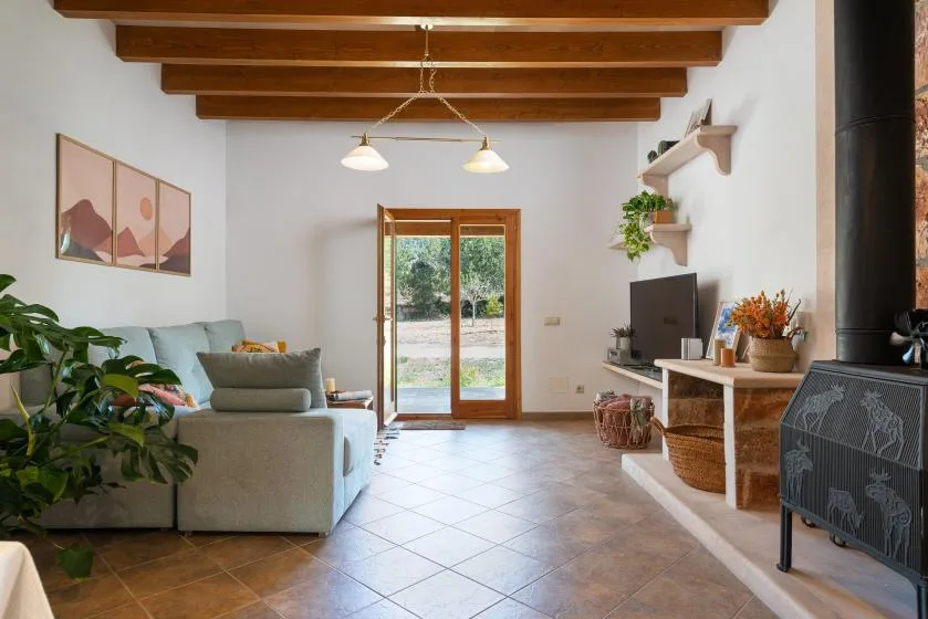 Una sala de estar con asientos, un televisor y un techo con vigas de madera.