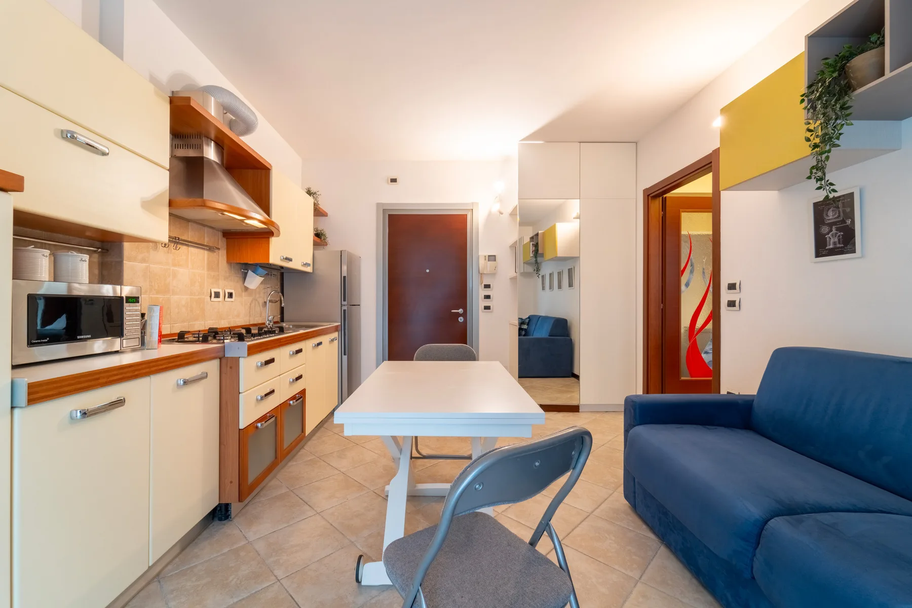 A compact kitchen and dining area with a table and blue seating.