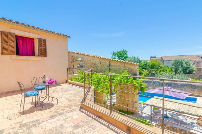 Una terraza soleada da a jardines verdes y una piscina.
