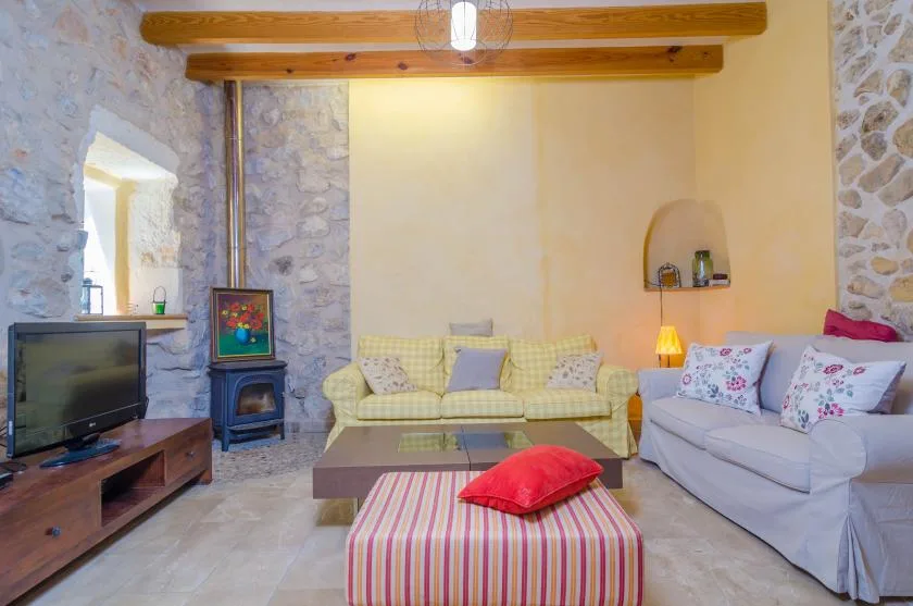 Una sala de estar con asientos alrededor de una mesa baja y un televisor.