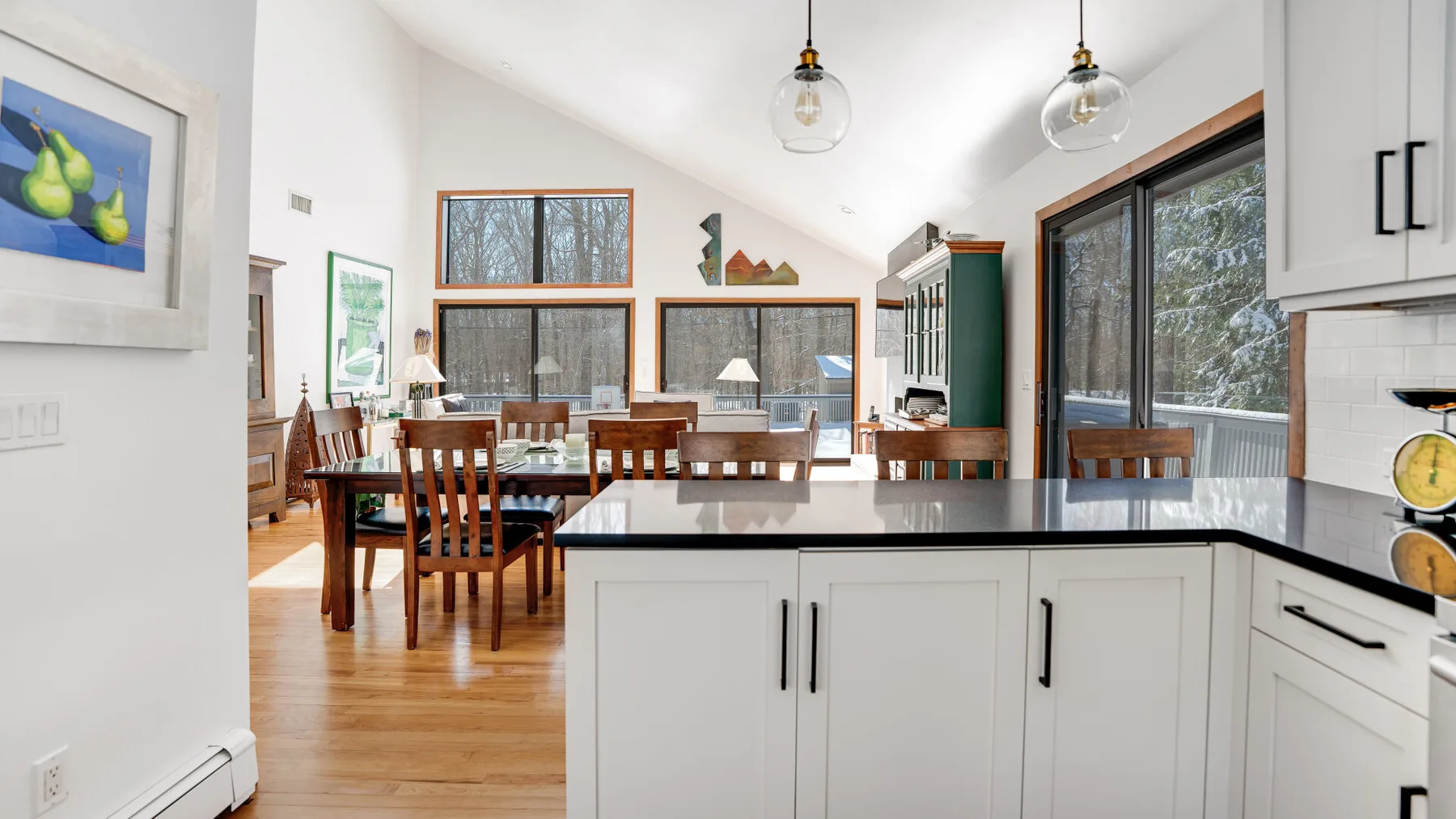 A bright open kitchen and dining area with a long wooden table.
