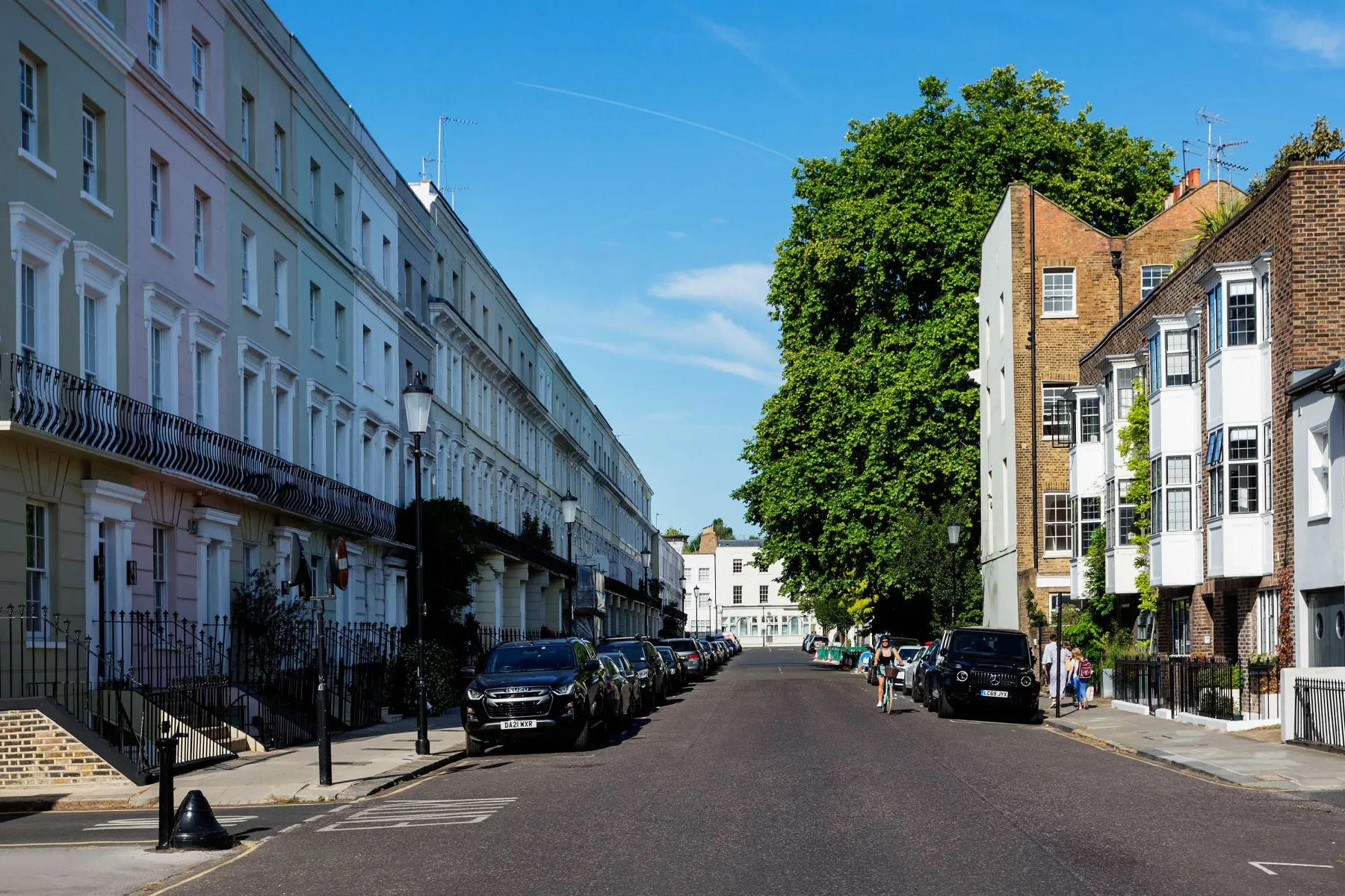 A quiet residential street lined with brick and stucco buildings.