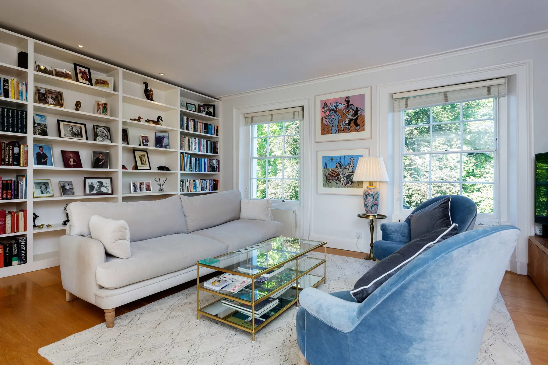 Living room with seating, built-in bookshelves, and large windows.