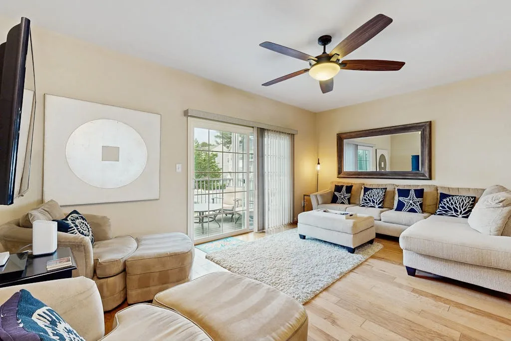 Living room with seating, a rug, and sliding glass doors.