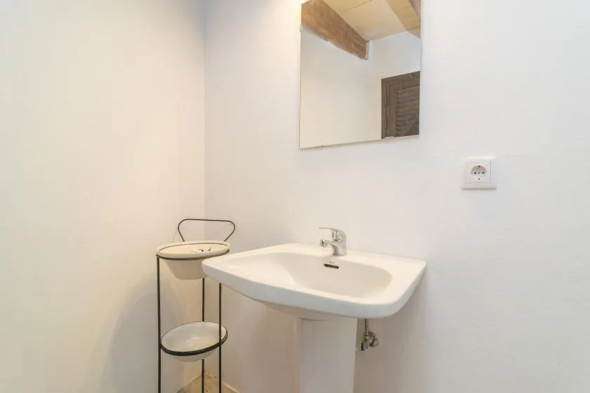 Un lavabo de baño está debajo de un espejo de pared.