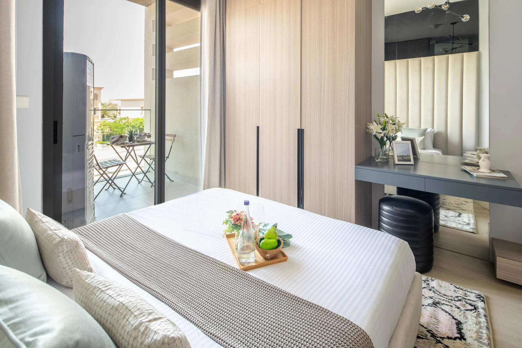 Un dormitorio con la cama tendida y un escritorio junto a la ventana.