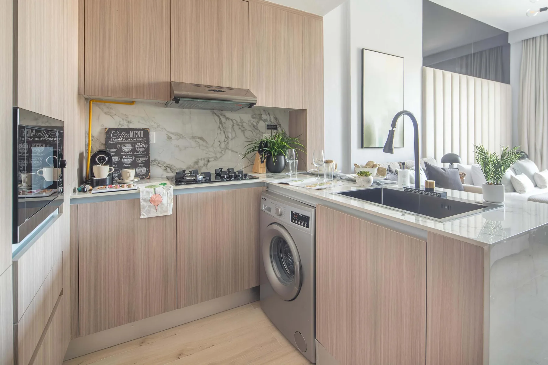 Una cocina moderna con gabinetes de madera, salpicadero de mármol e isla central.