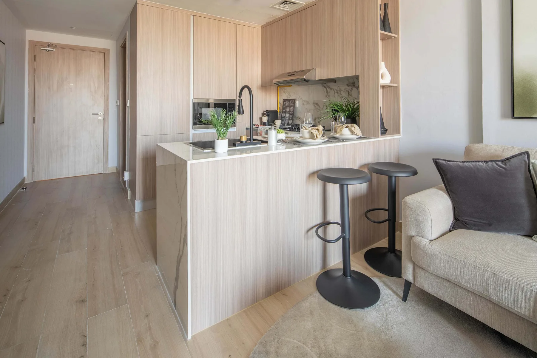 Una cocina abierta y luminosa con zona de estar, barra y asientos.