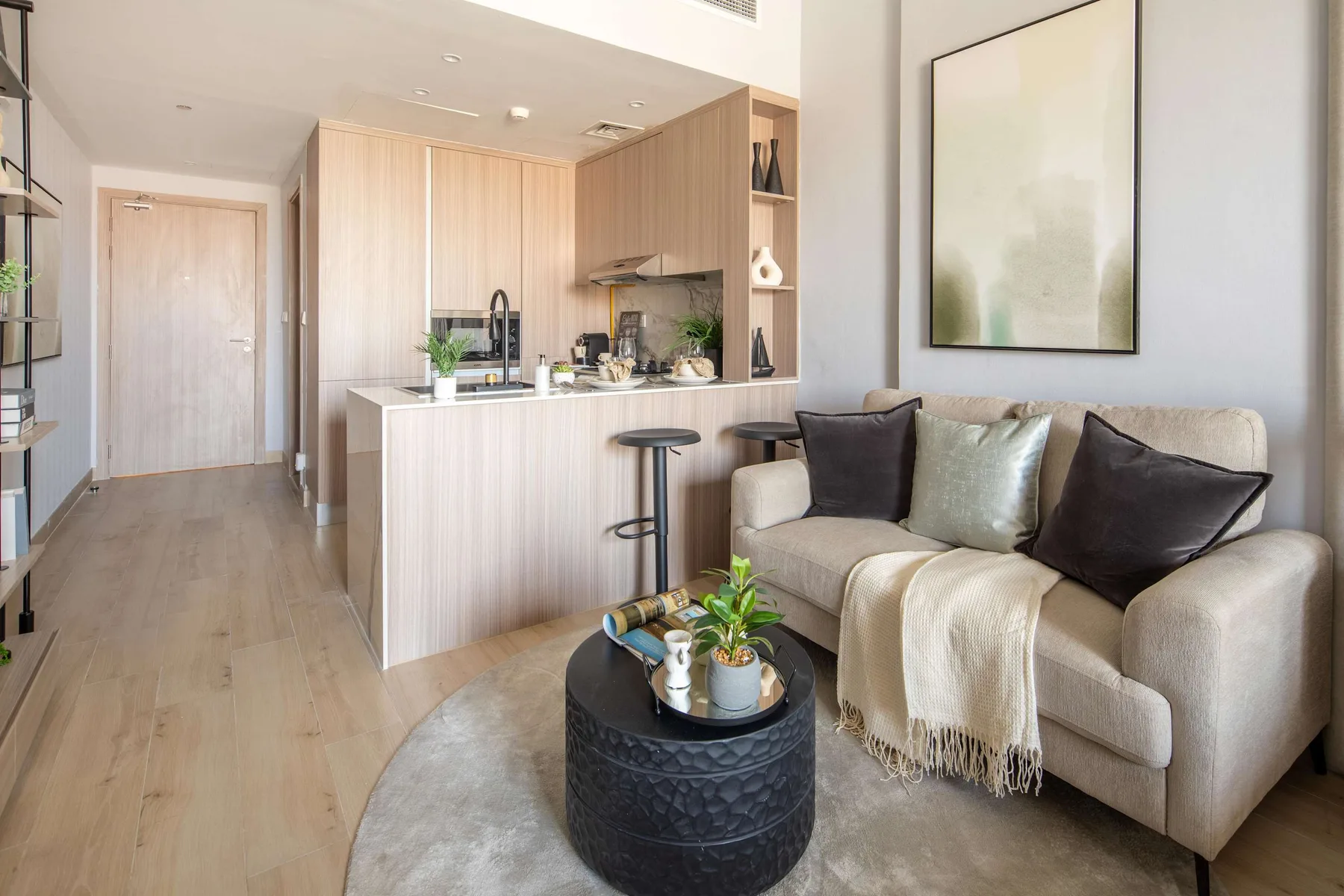 A bright open-plan living area with seating beside a kitchen island.