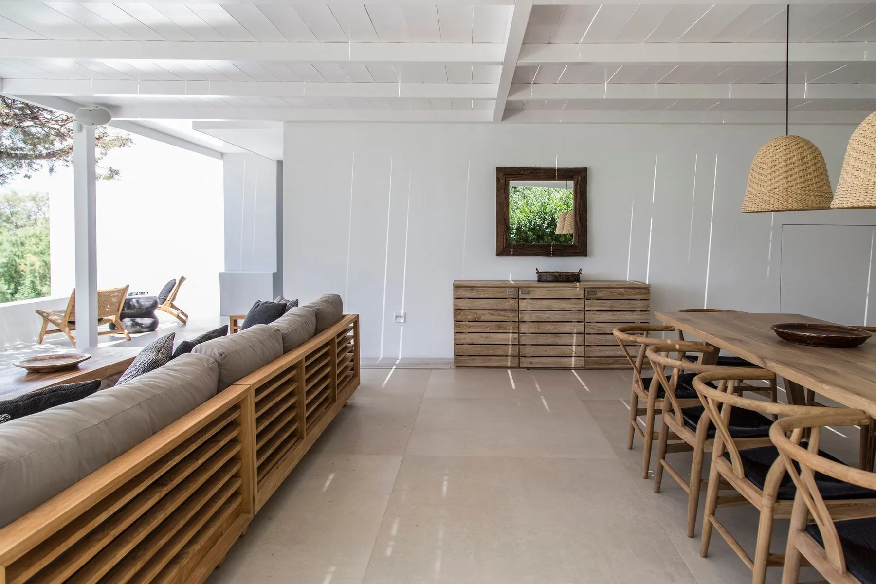 Una luminosa sala de estar y comedor de planta abierta con una mesa de comedor de madera.
