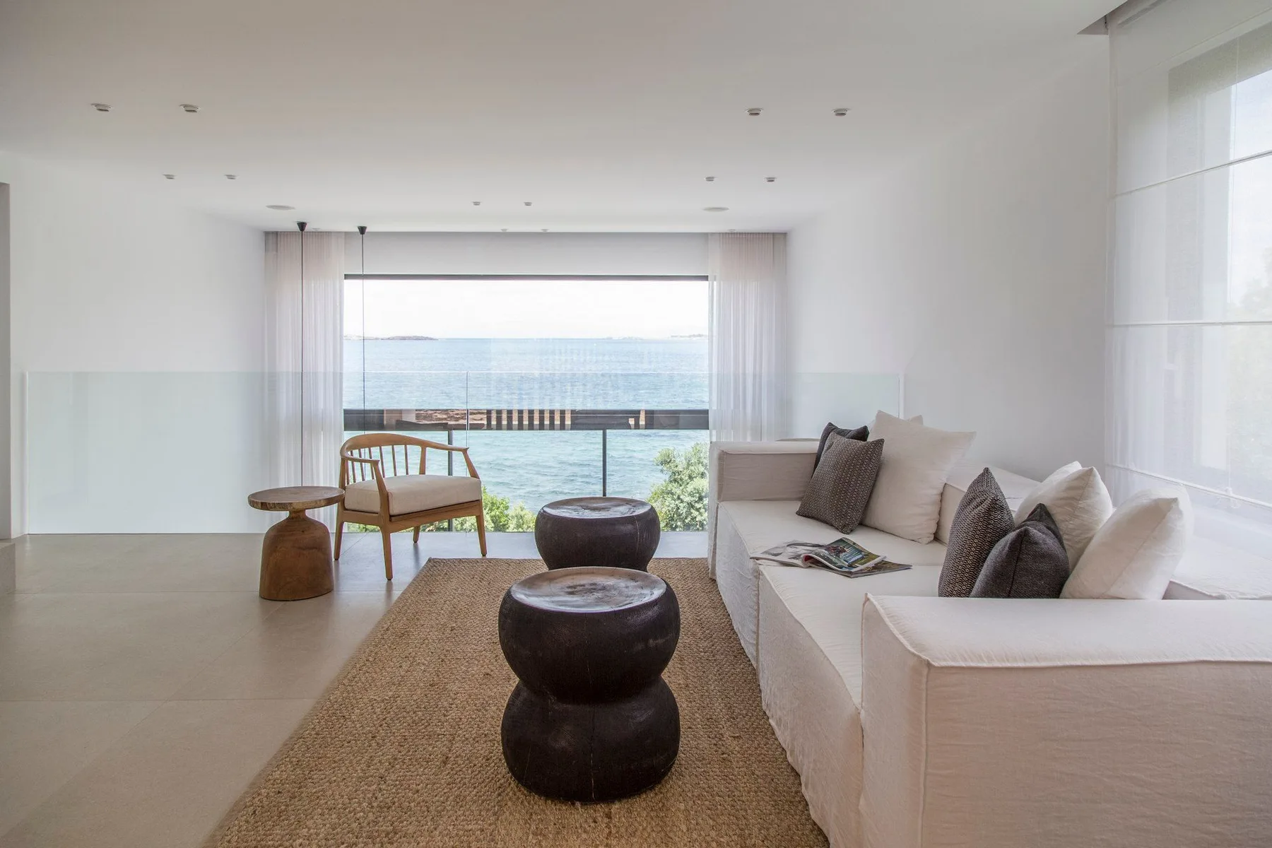 Una luminosa sala de estar con asientos y vistas al mar.