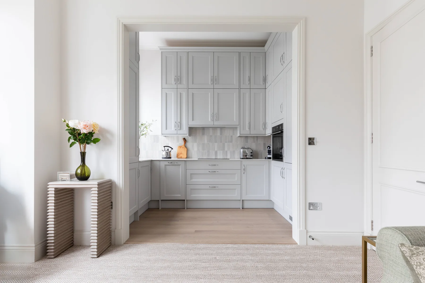 A bright kitchen with white cabinets and a central work surface.